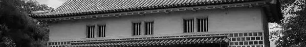 A small Asian architecture house overhanging a road.